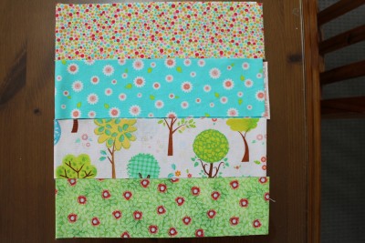 Firstly I cut the 8 different materials into 3 inch strips (each is the full width of the material). I then match two groups of four strips. Here are the blue/green strips.