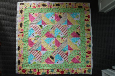 Because this is a smallish quilt (or blanket) there is no need to top stitch through all layers. On this one I have added the wadding to the back, and if you look closely, I have top stitched through both of the layers. This keeps the blanket looking neat and holding together well after many washes. There are many ways that you can top stitch on a quilt. I have just made quarter inch lines alongside the seams and it looks very tidy.