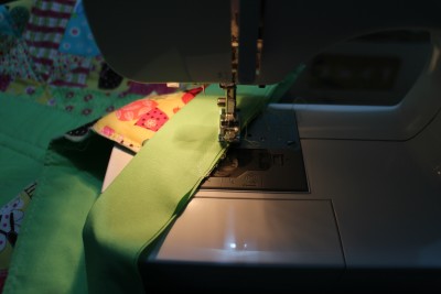 With the cut edges together sew the binding on stopping about a quarter of an inch from the corner and sew diagonally off the edge.