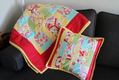 And with the little pieces of fabric that I had left over I made a pillow to match! I'm rather proud of how they both turned out. The pillow was just little strips sewn together and the red used as a filler to make them square :-)